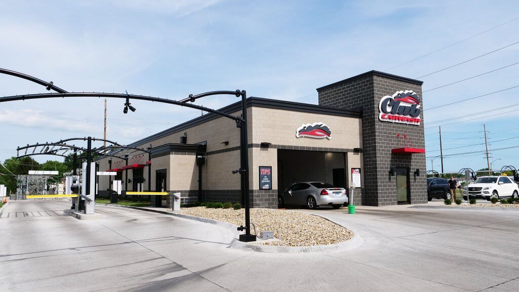 ground view of location with club car wash logo on building tower to the right and entry lanes on the left of screen