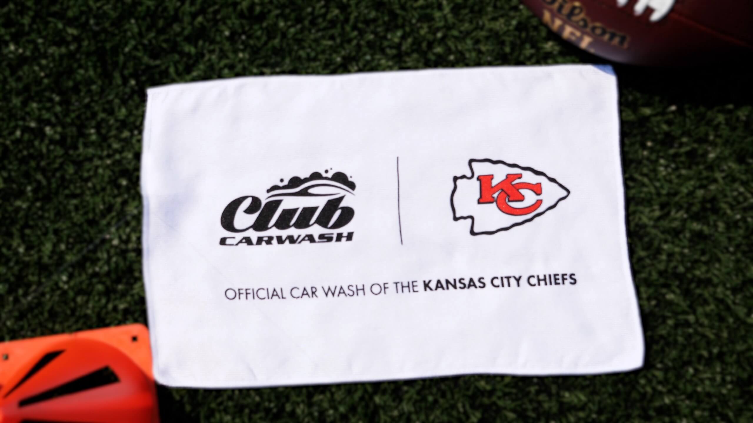 Club car wash logo on left next to chiefs arrowhead logo on the right